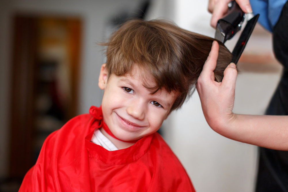 Little boy at professional barber, hair saloon